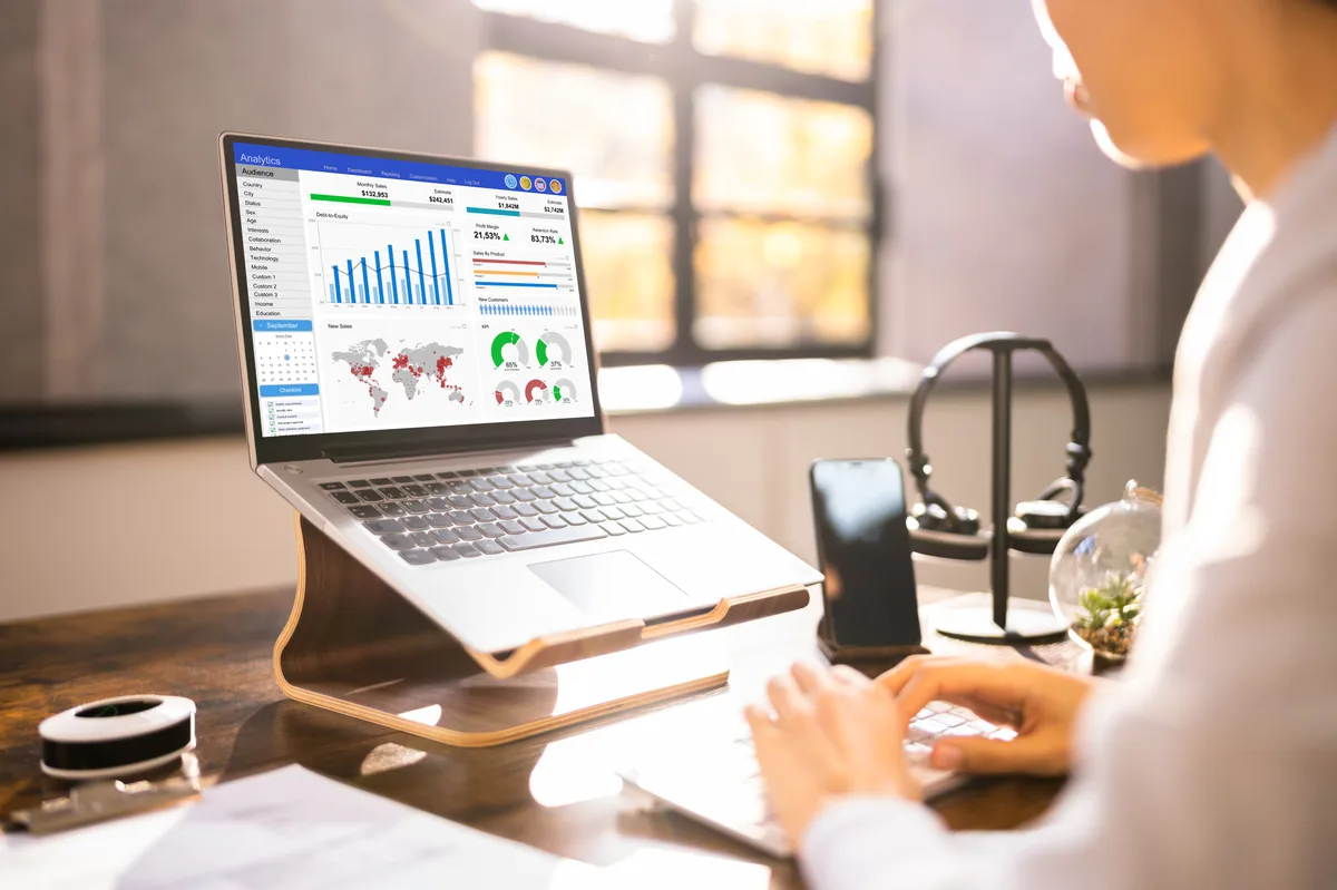 Business owner reviewing inbound lead sources and analytics on a laptop in a small office