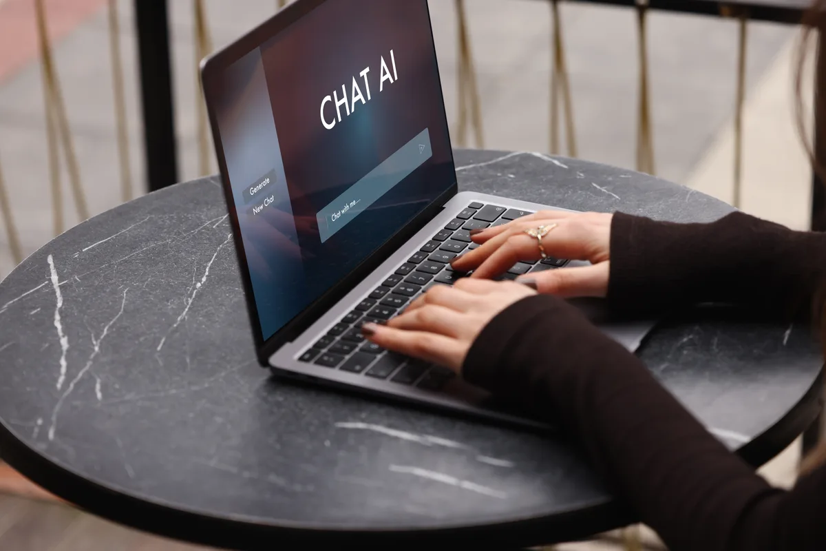 Business owner using a laptop with an AI assistant interface on screen