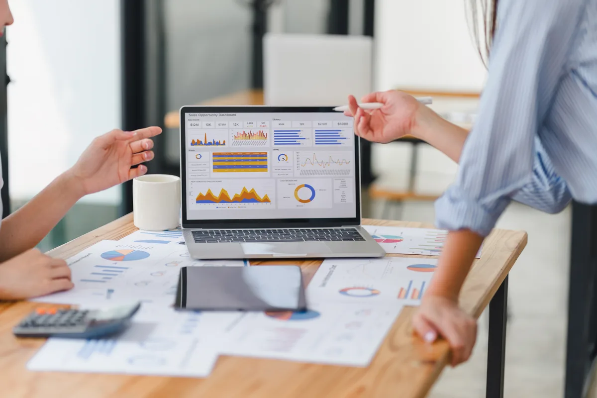 Two analysts reviewing a marketing analytics dashboard for AI-driven mentions