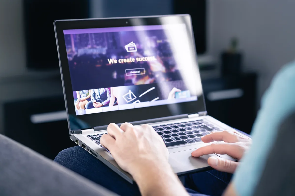 Designer building a new business website homepage on a laptop