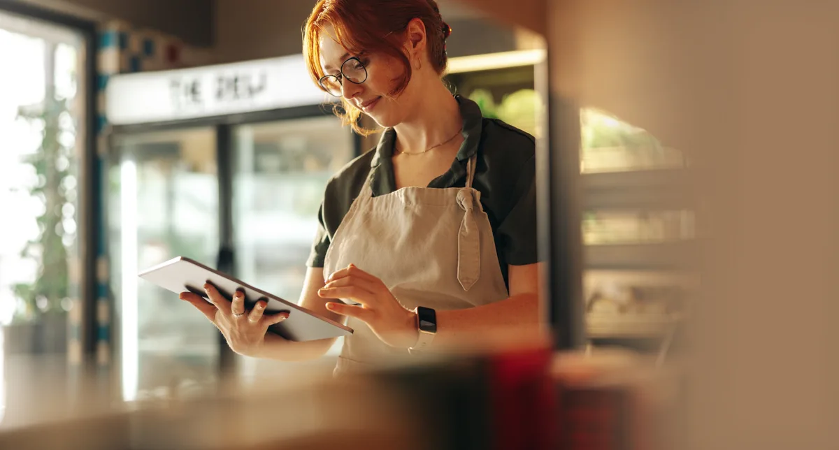 Grocery store owner checking her shop's online visibility on a tablet