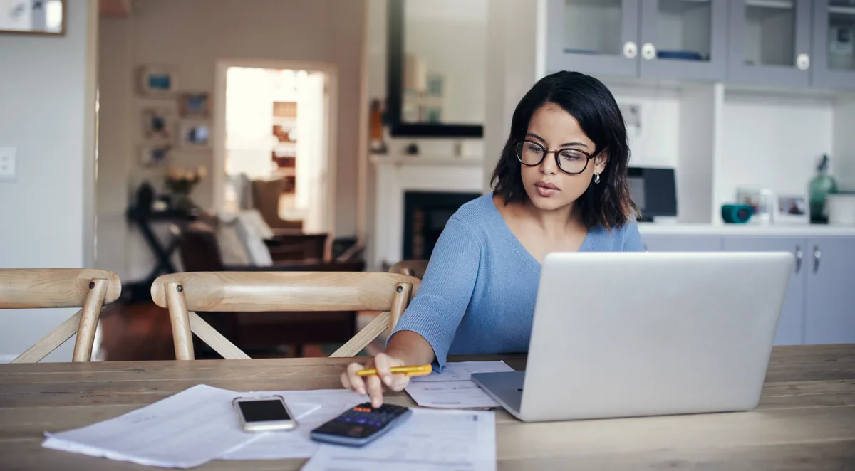 Small-business owners working out their marketing budget with a calculator