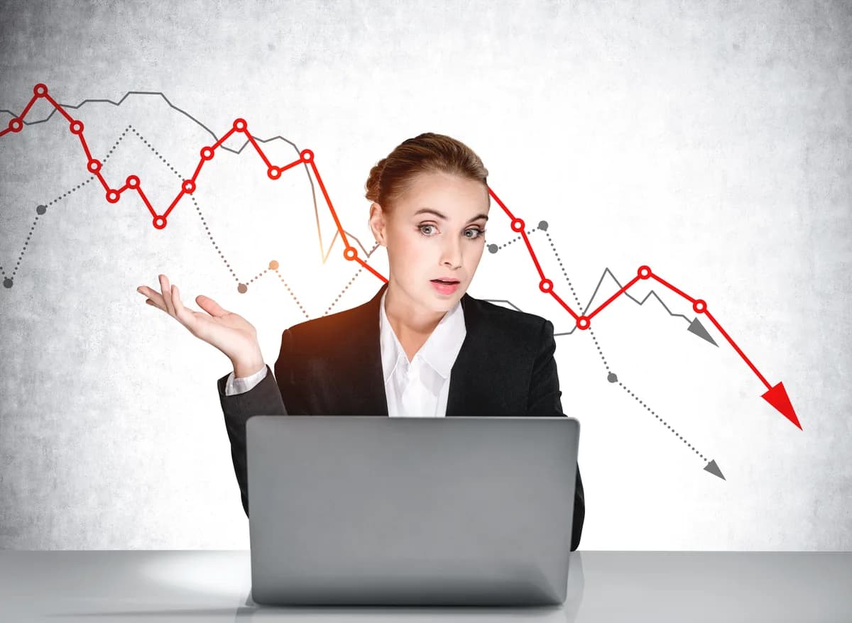 Marketer studying a declining conversion graph next to her laptop