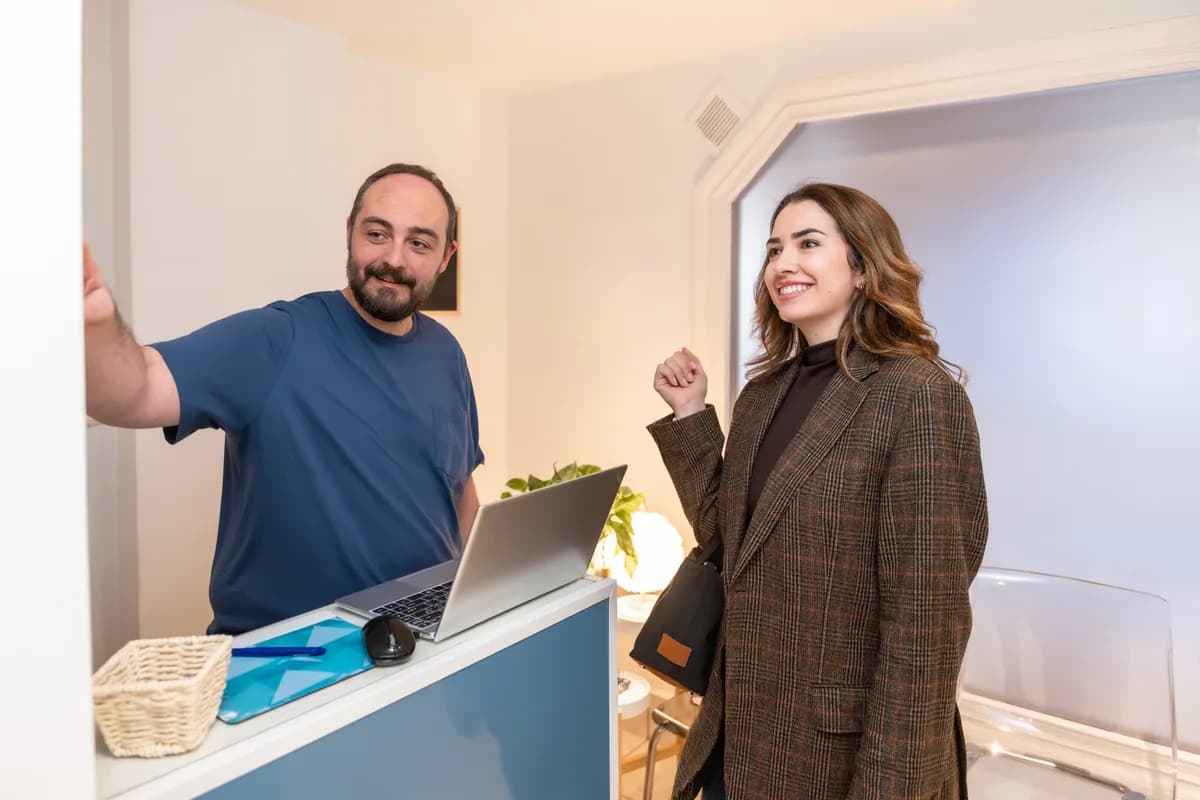Chiropractor reviewing a treatment plan with a patient at a clinic reception desk