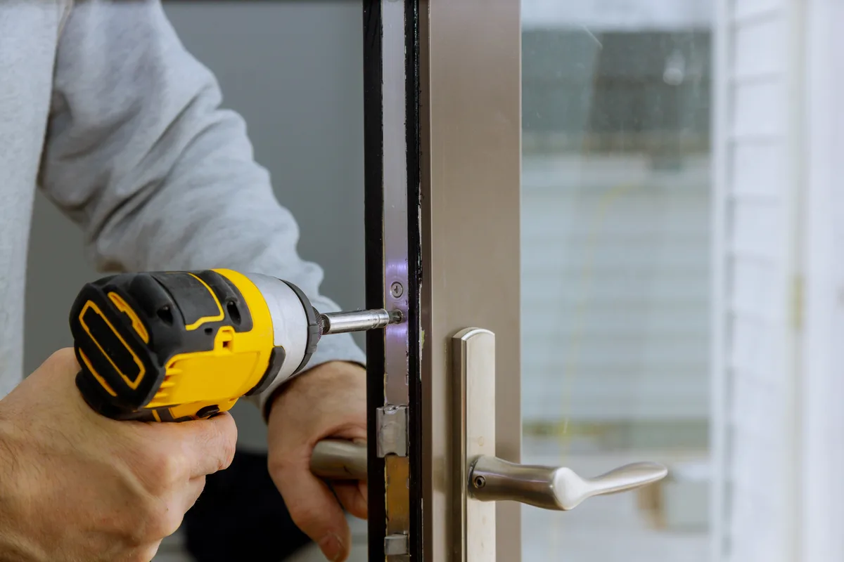 Locksmith fitting a deadbolt at a home's front door during a service call