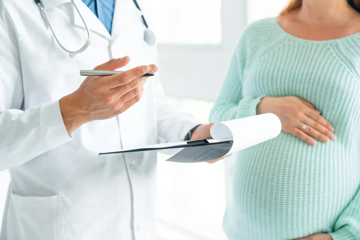 An OB/GYN physician reviewing care options with a woman patient in a bright modern consultation room