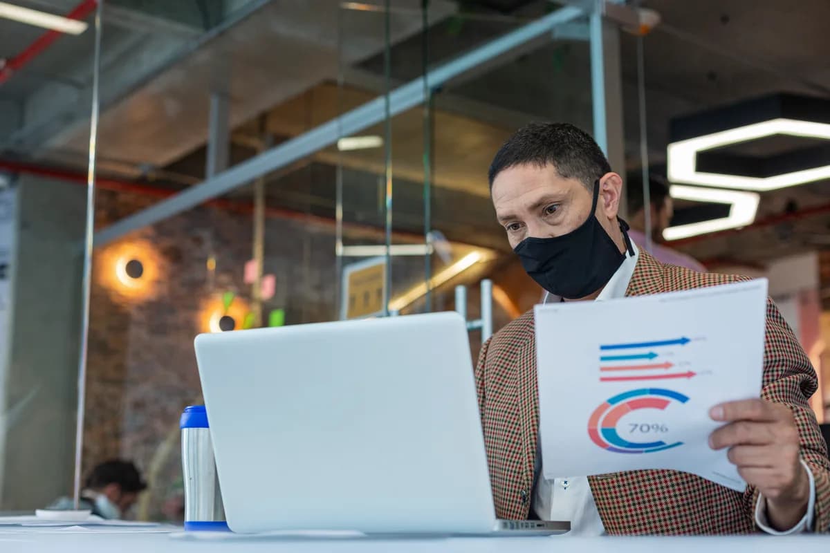 Pest control company owner reviewing lead and booking reports on a laptop at a desk