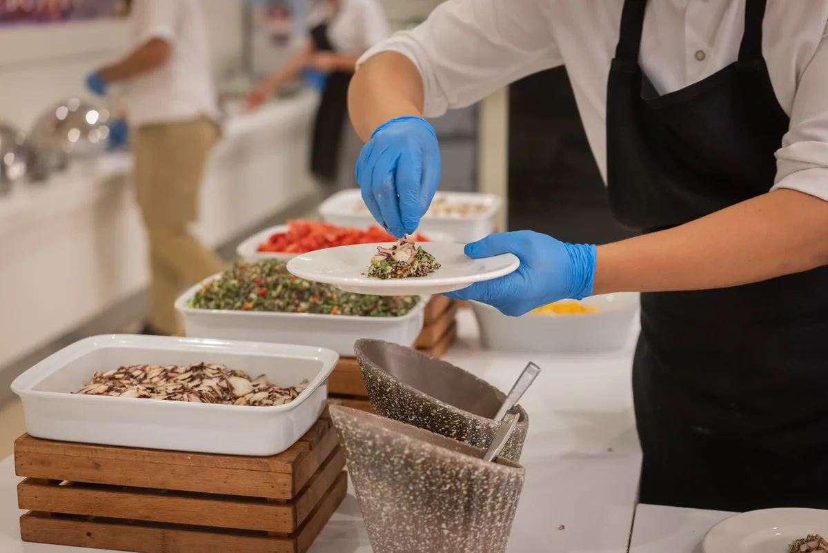 Catering team plating dishes at a buffet station during a corporate event