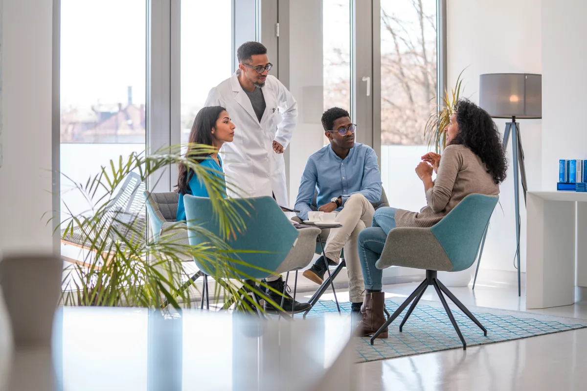 A board-certified plastic surgeon reviewing options with a prospective patient during a consultation in a bright modern clinic