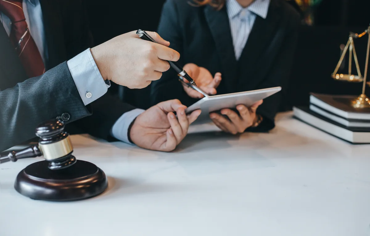 Criminal defense attorney reviewing case documents with a client across a desk in a law office