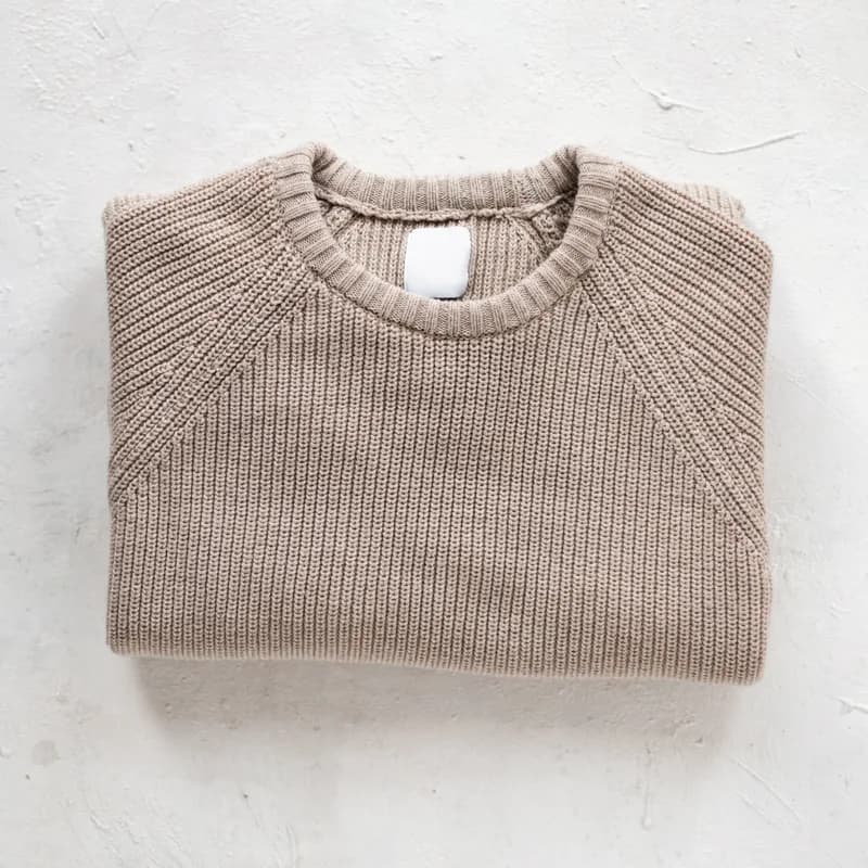 Crest Henley knit in oatmeal slub jersey, folded flat on a plaster worktable