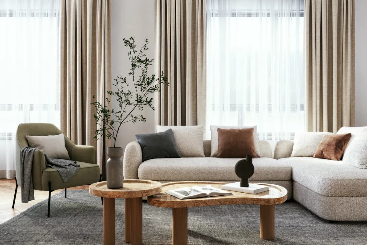 Sunlit living room styled with a low sofa, lounge chair, and natural textiles