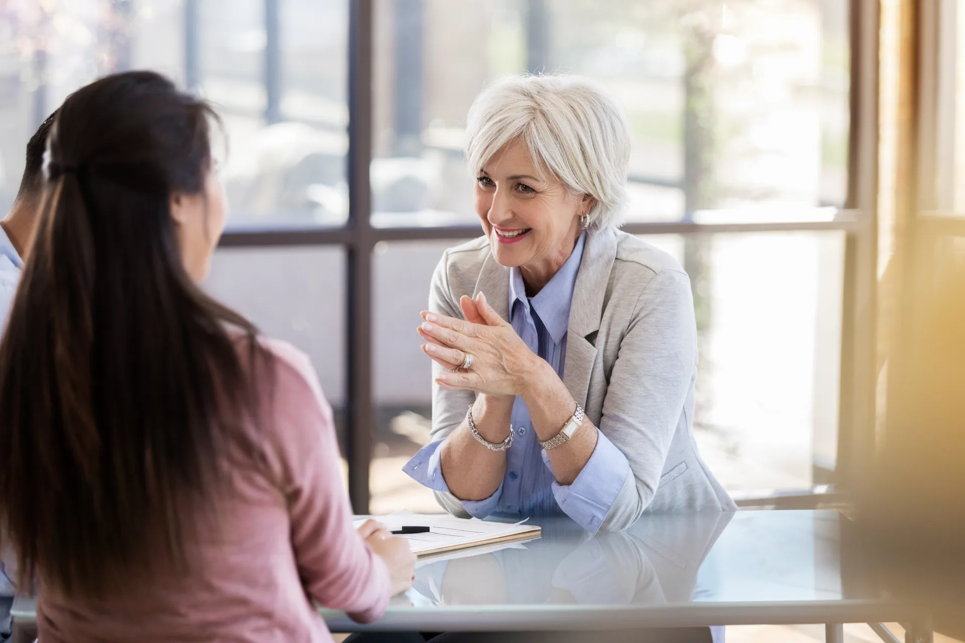 A therapist in conversation with a client at a sunlit office