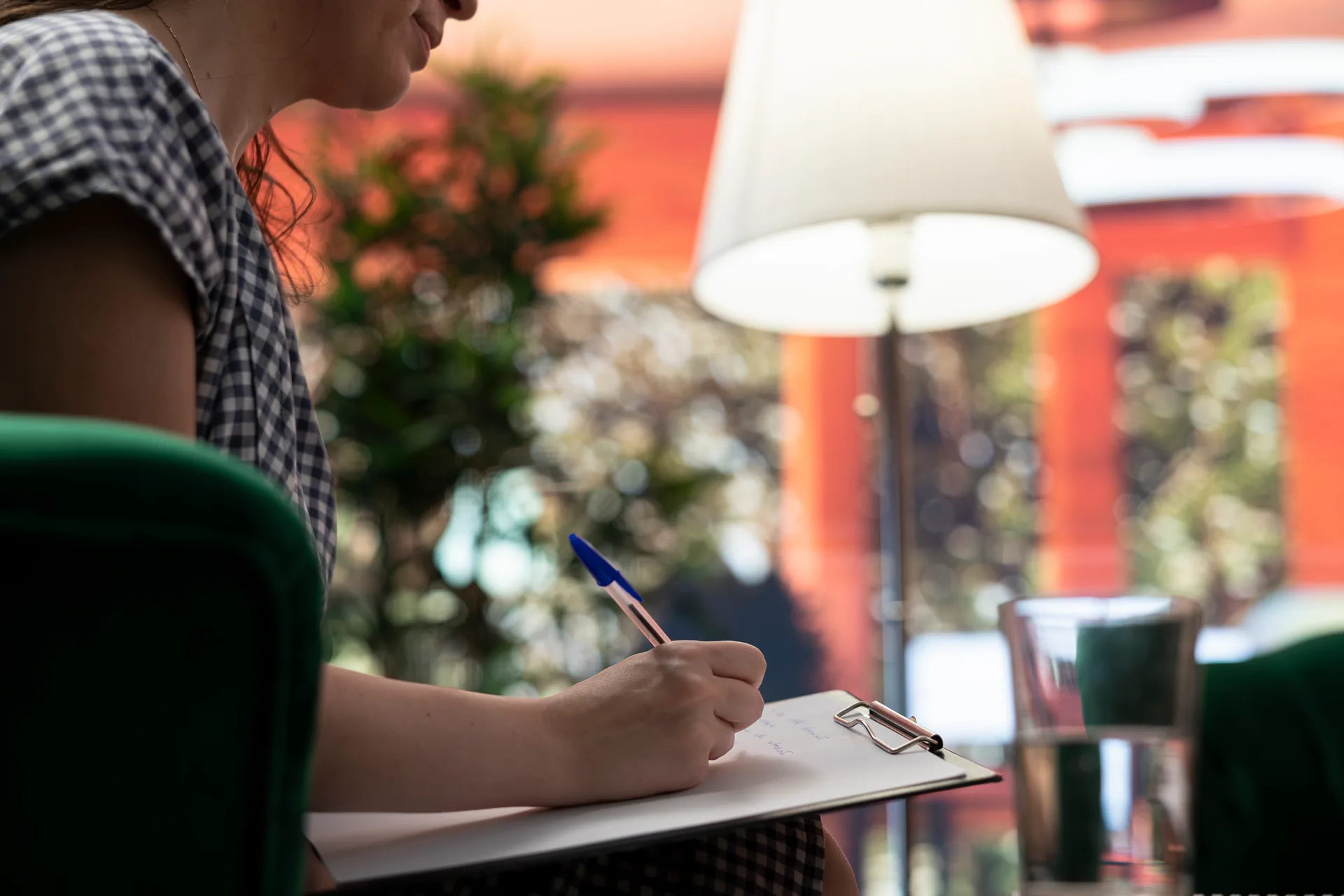 A therapist taking notes on a clipboard during a session