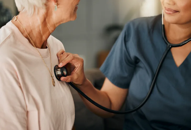 Nurse listening to a senior patient's heart