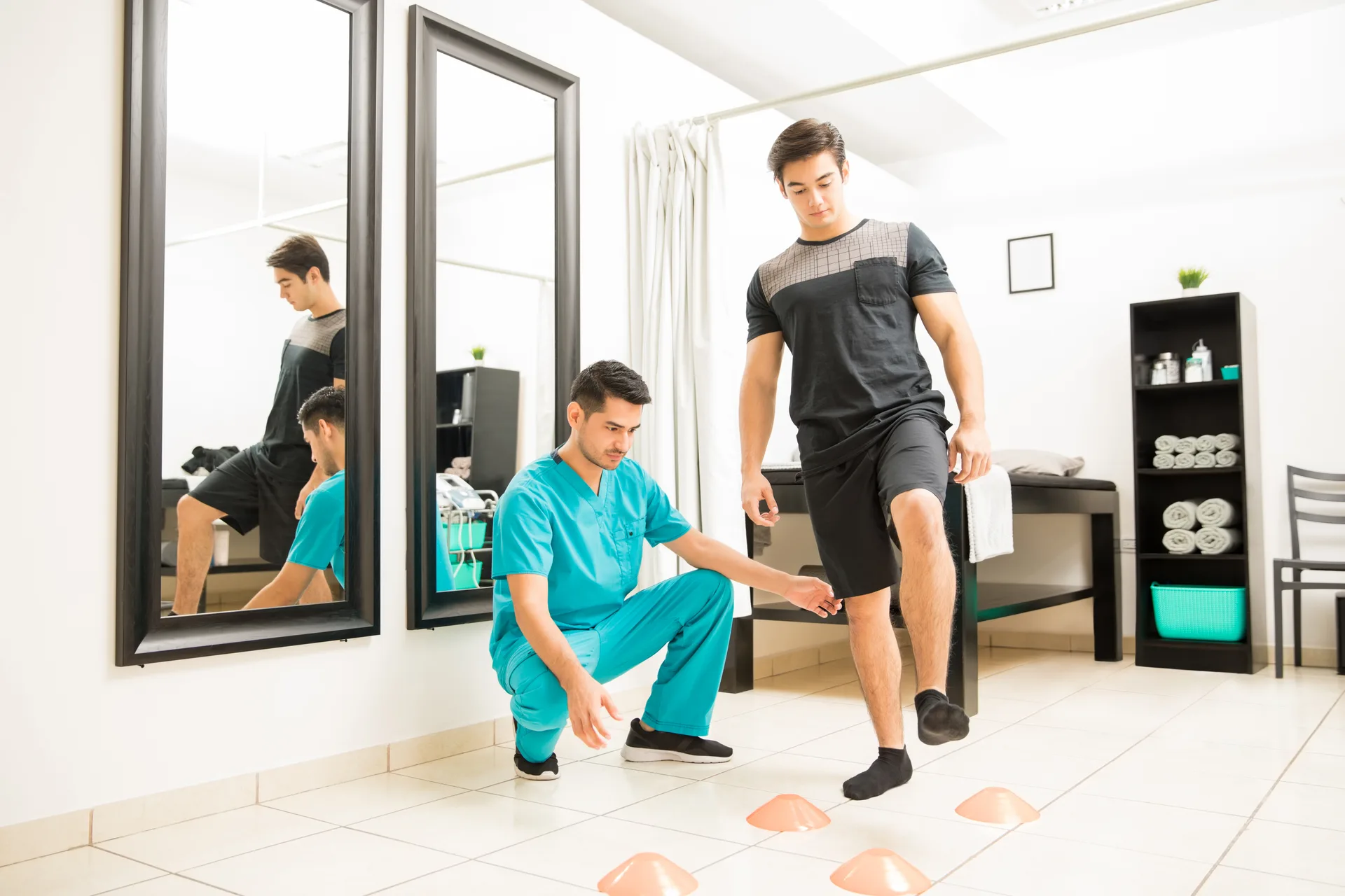 A therapist guiding a patient through a walking movement assessment between cones
