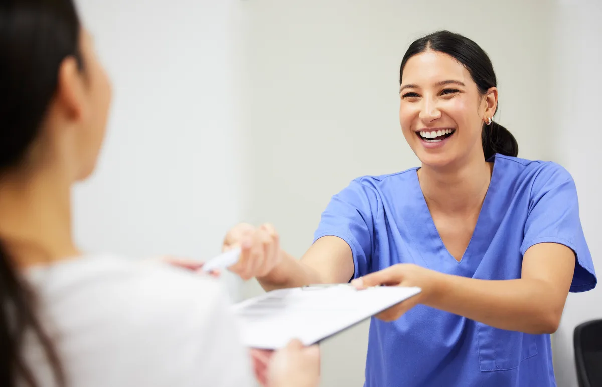 A warm, modern dental clinic with a patient and assistant in conversation