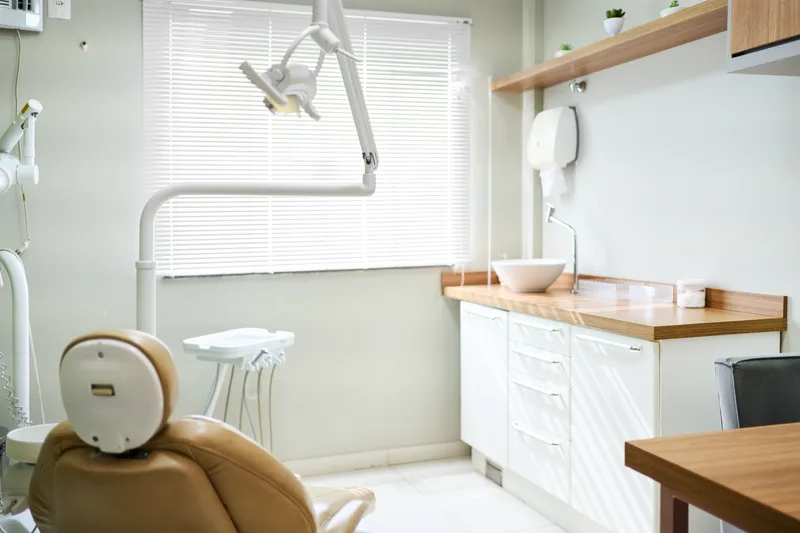 Warm wood-toned dental operatory with a treatment chair