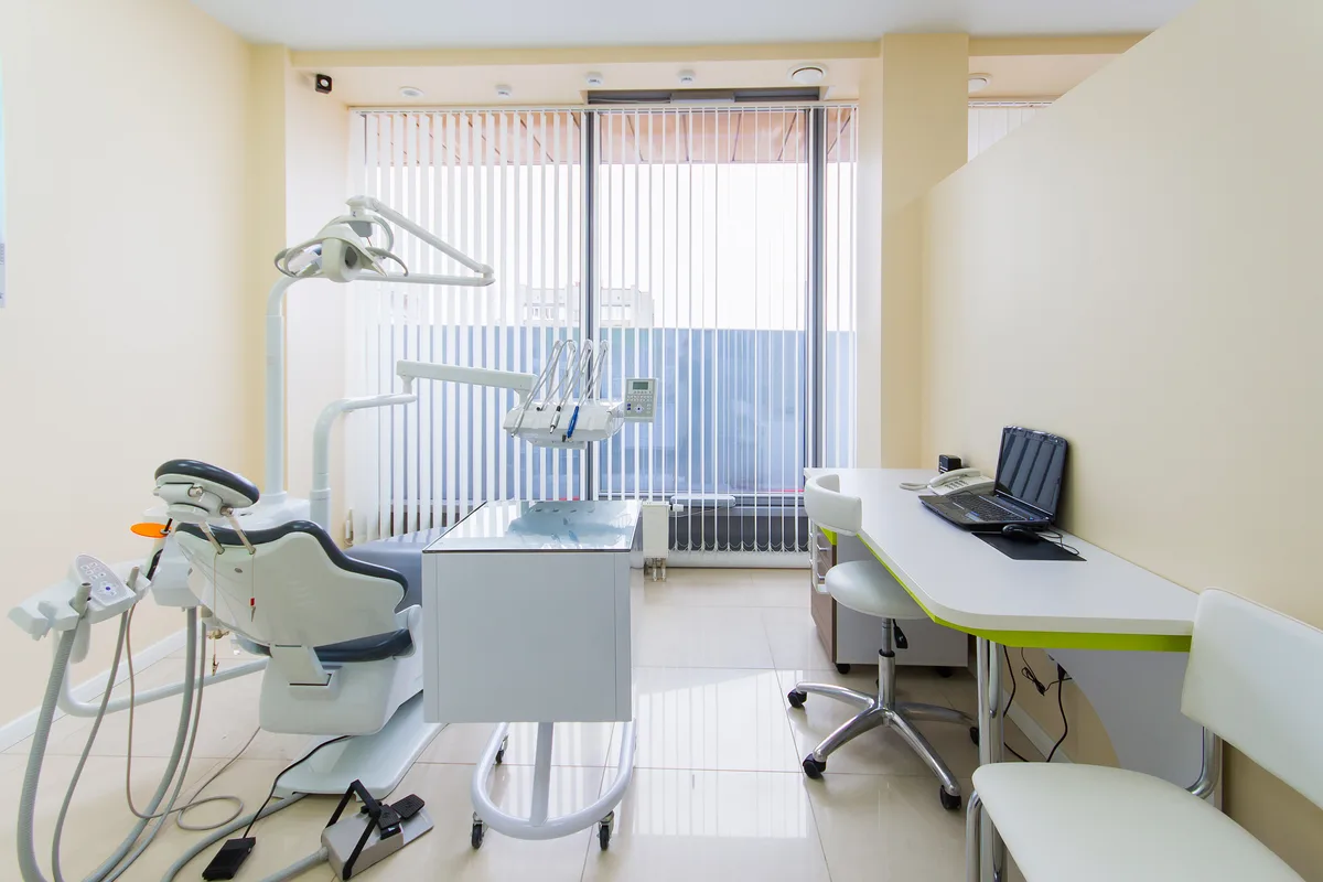 Bright dental clinic reception with seating area and counter