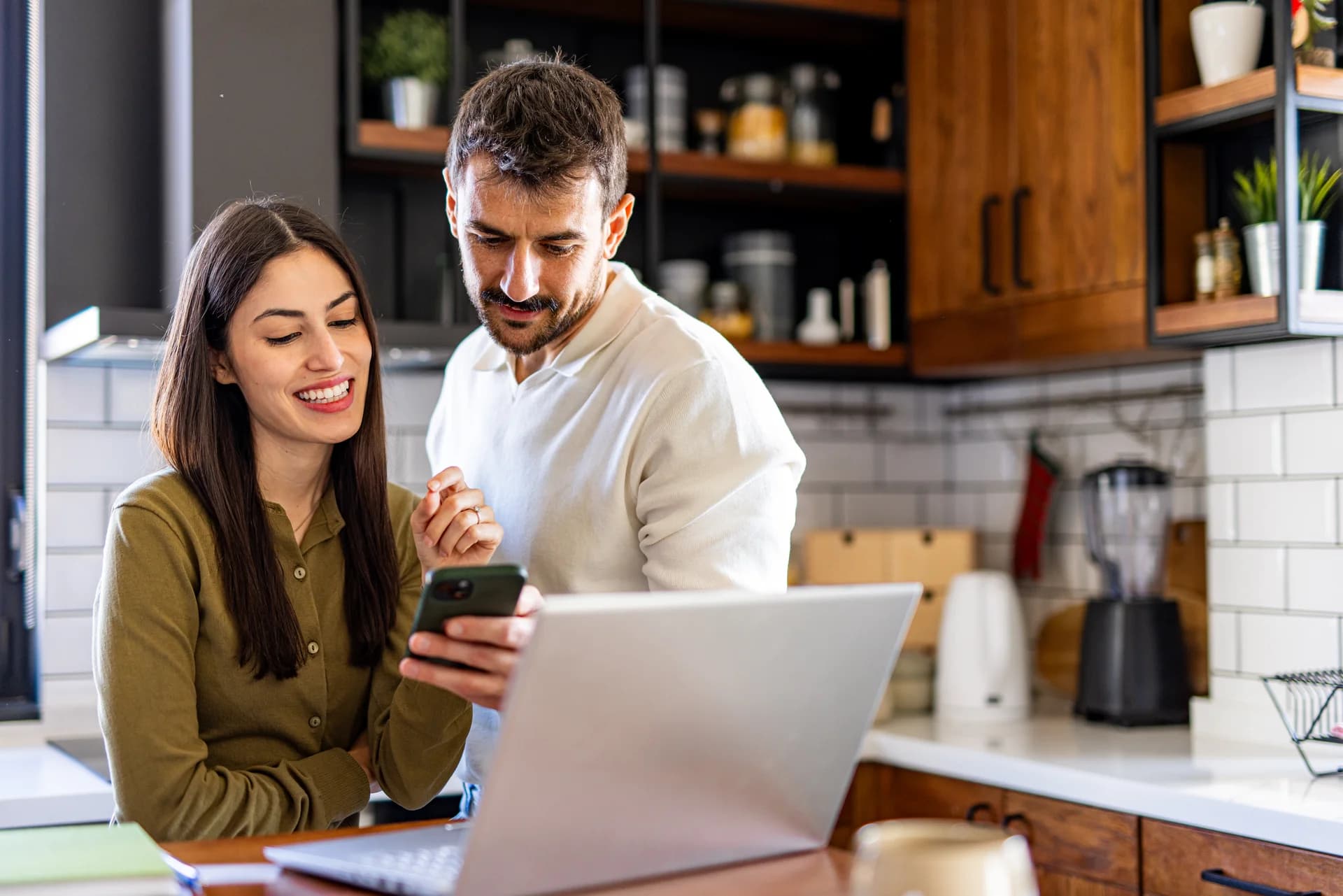 A young couple checking finances together at the kitchen table