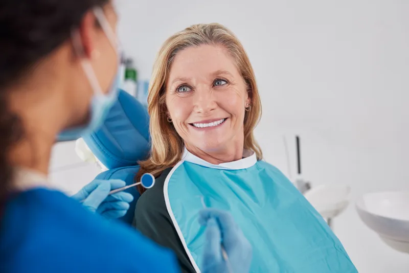 A patient smiling with a specialist after an implant-supported restoration