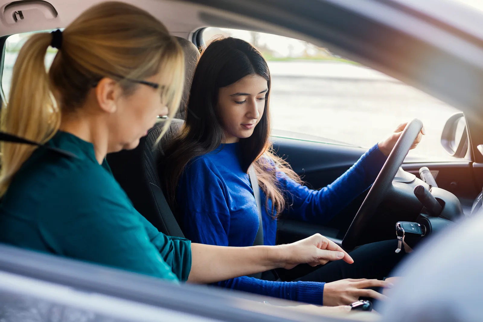 Driving instructor teaching a student driver in a car