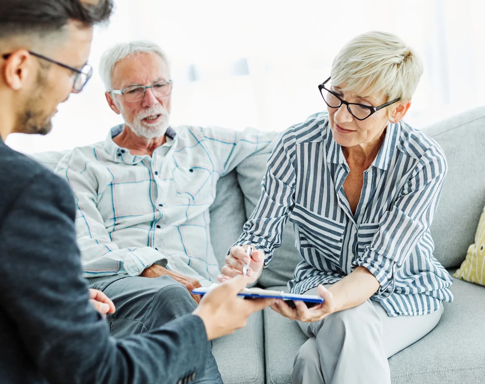 Estate planning attorney reviewing documents with a senior couple in an office