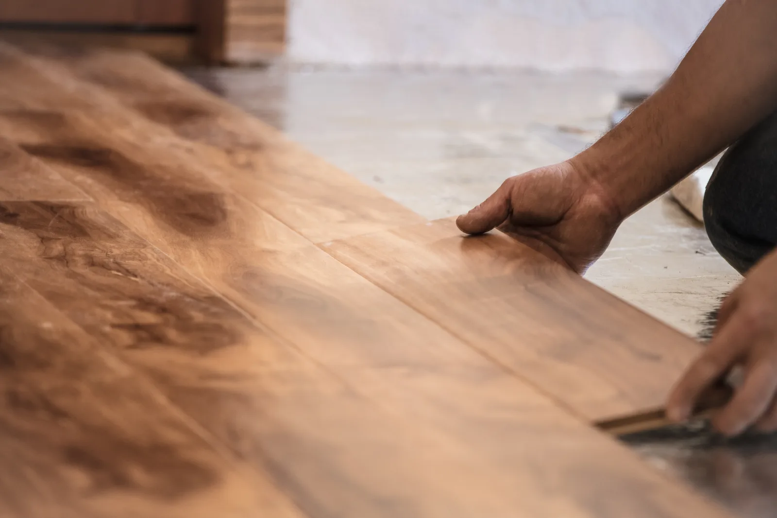 Worker installing hardwood flooring in a home