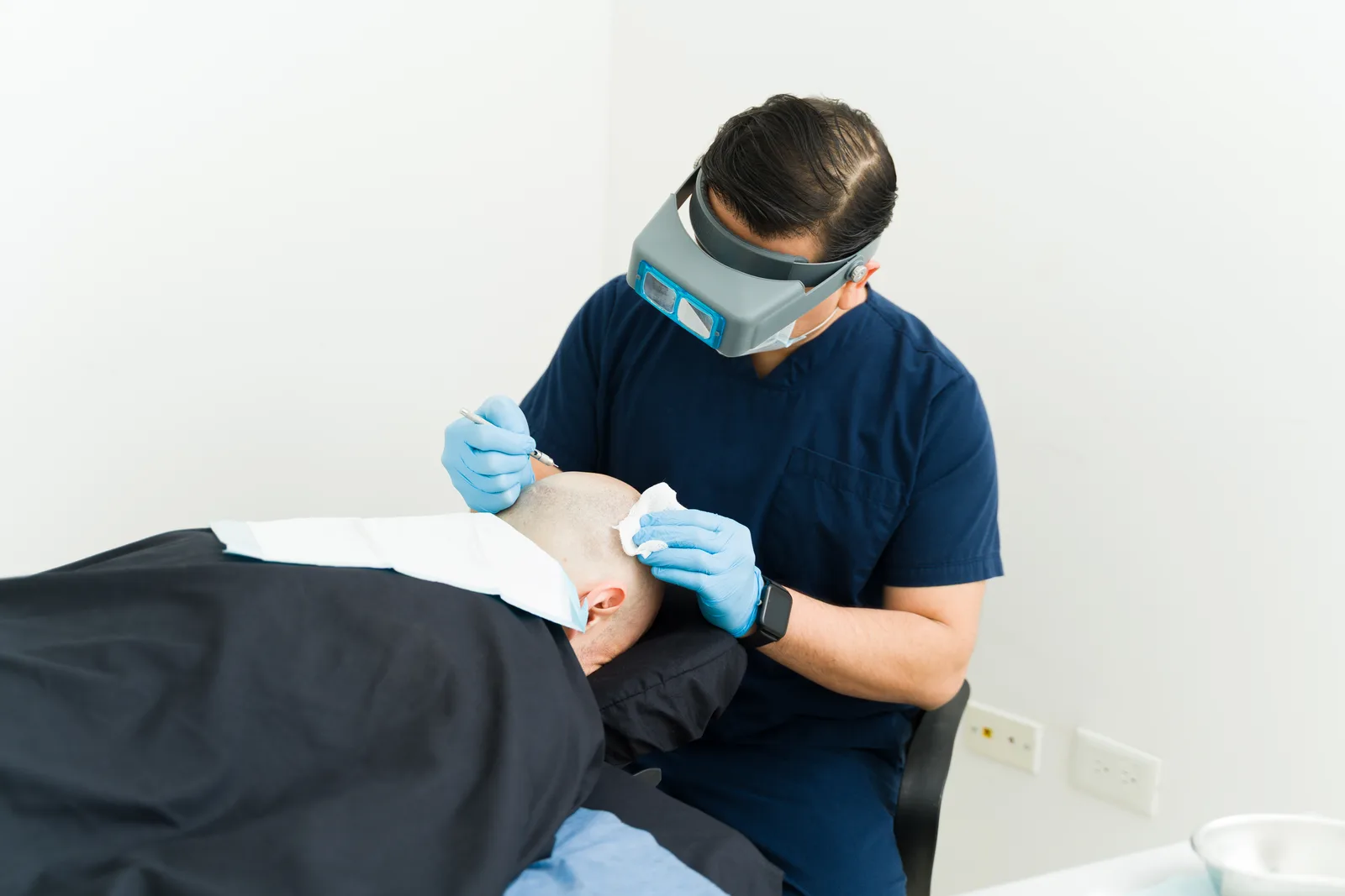 Hair restoration surgeon performing a follicle transplant procedure on a patient