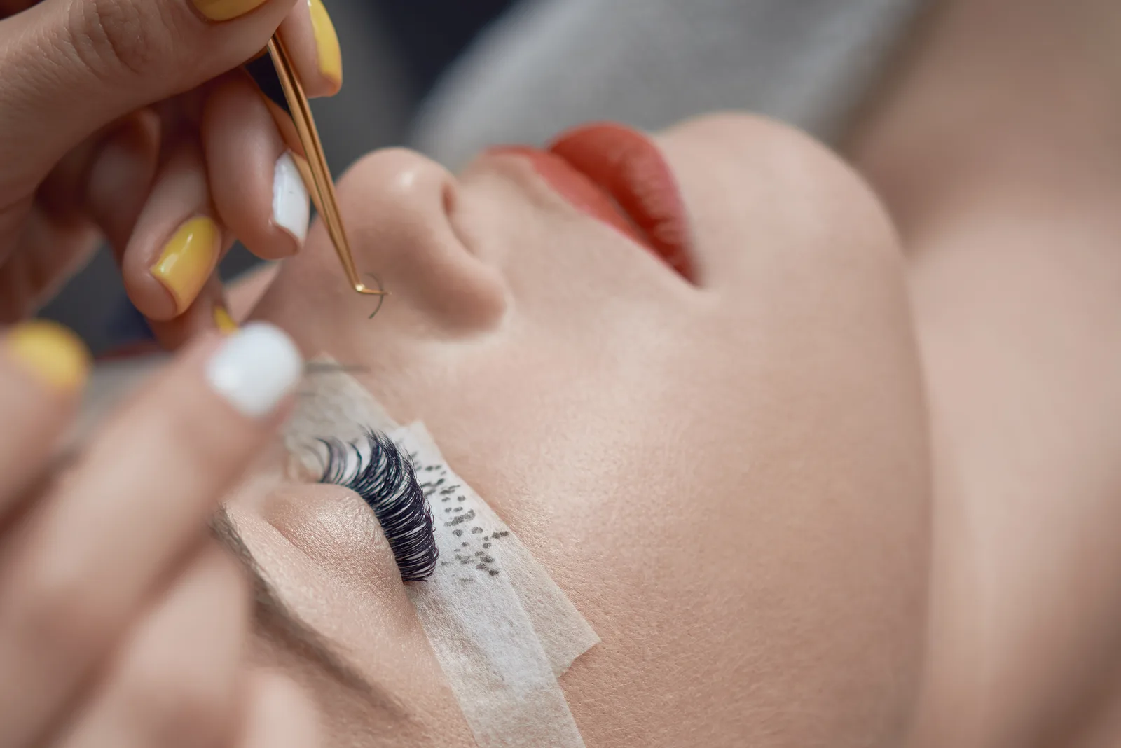 Lash technician applying eyelash extensions to a client