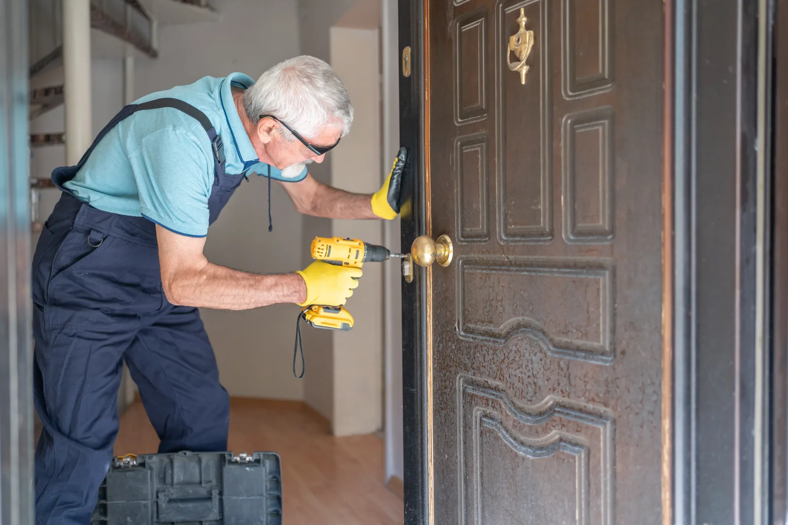 Locksmith changing a door lock at a home entrance