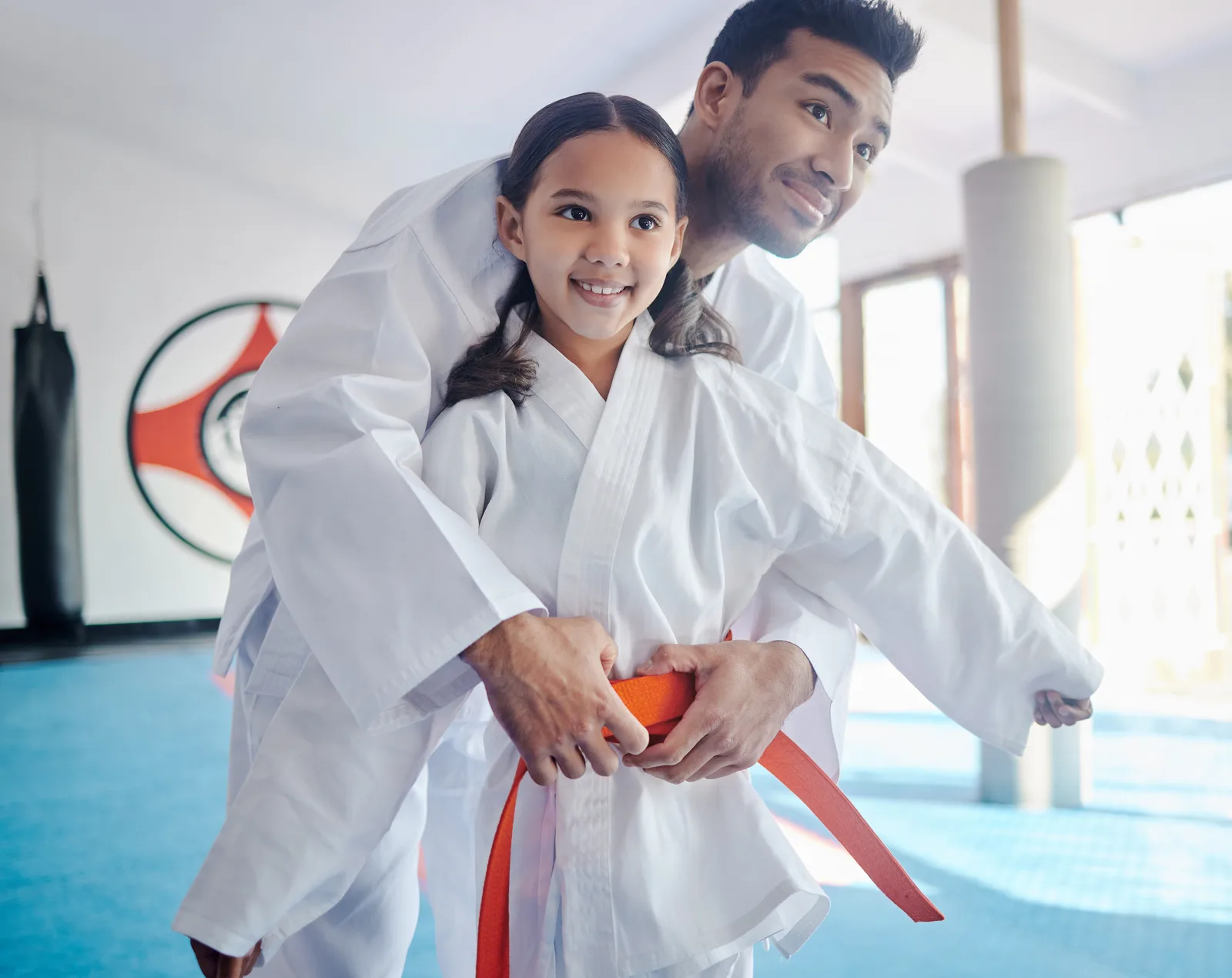 Martial arts instructor teaching a child karate in a dojo