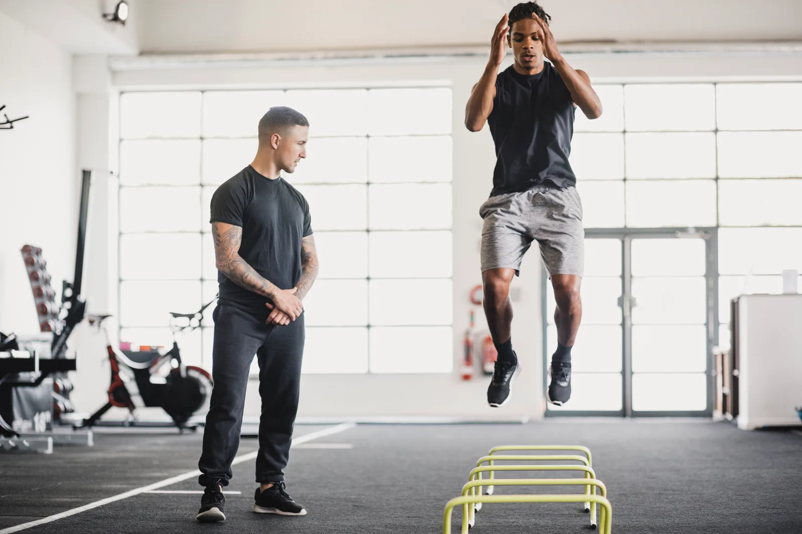 Personal trainer coaching a client through a strength workout in a gym