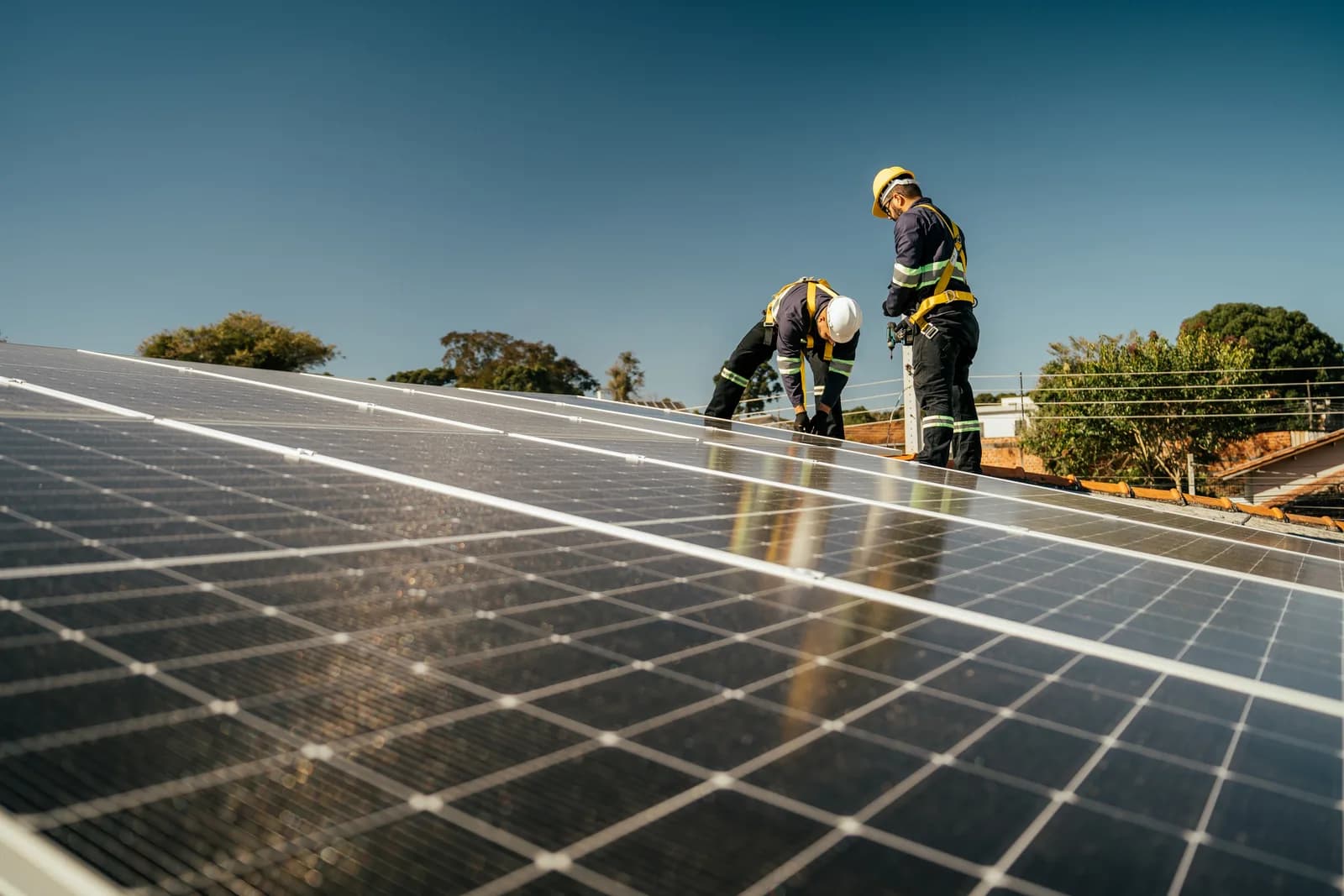 Workers installing solar panels on a residential roof