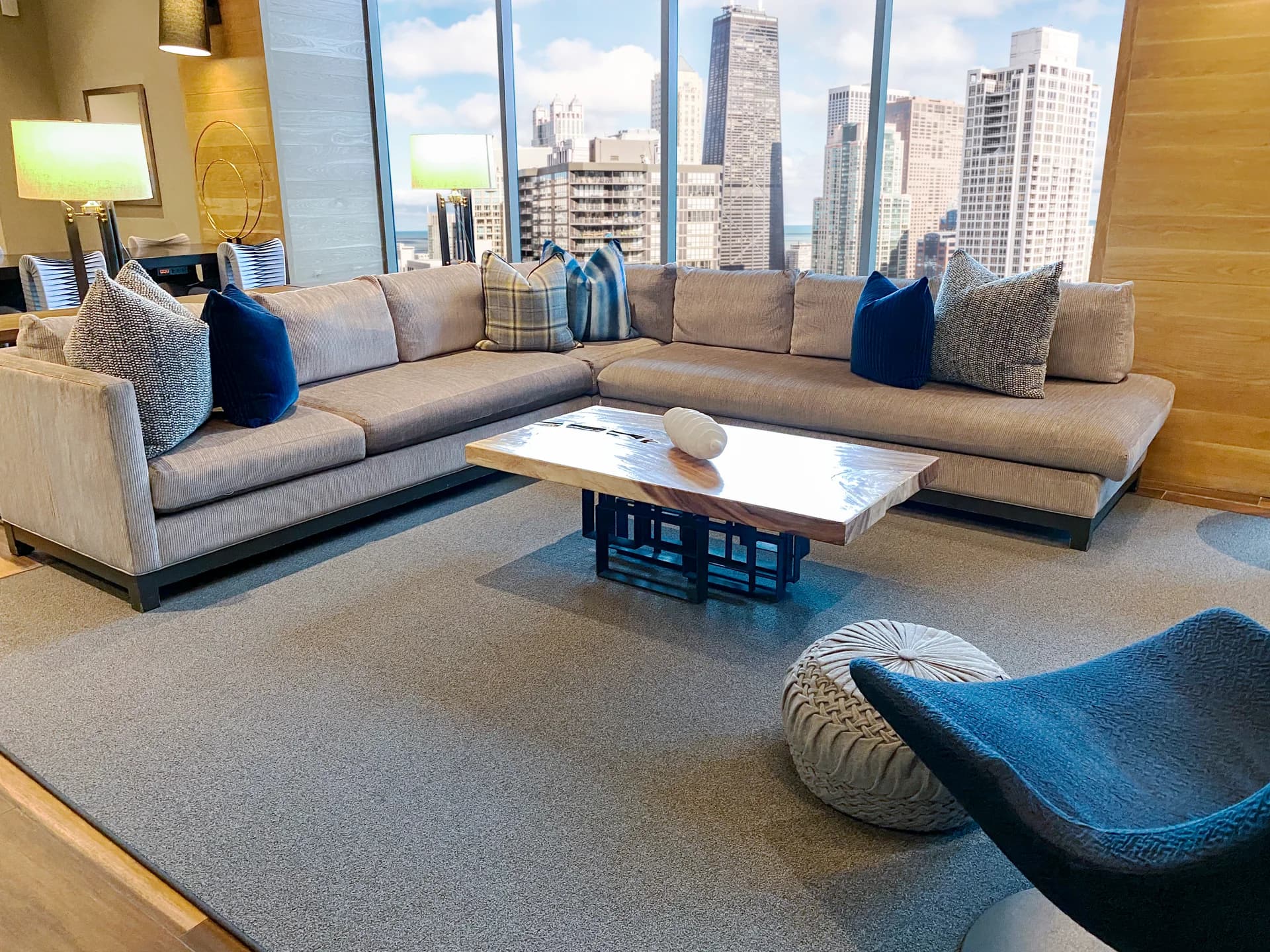 Floor-to-ceiling windows facing East River, golden-hour interior light.